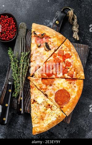 Ensemble de différentes tranches de pizza. Arrière-plan noir. Vue de dessus Banque D'Images