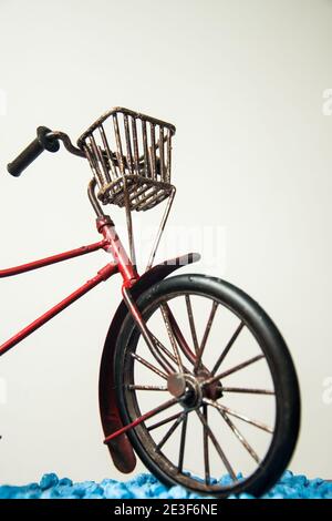 Vélo rouge vintage avec un panier en métal avec un blanc arrière-plan Banque D'Images