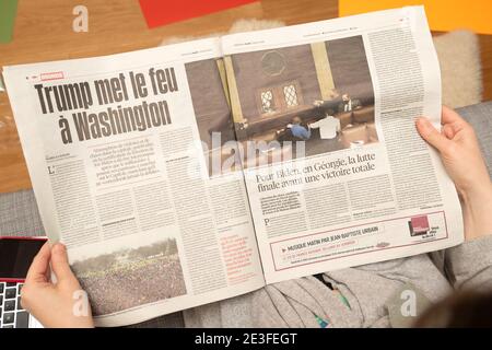 Paris, France - 7 janvier 2020: Une femme lisant sur son canapé journal français libération interiour page show storming of the U.S. Capitol by Supporters of U.S. President Donald Trump on January 07, 2021 Banque D'Images