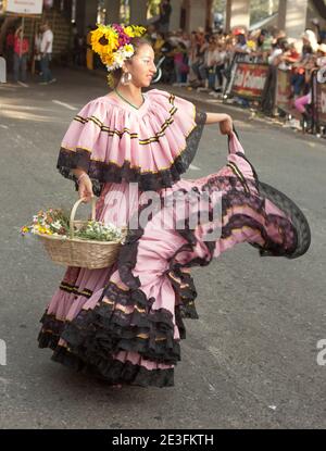 Femme vêtue d'une robe traditionnelle, dansant dans le Desfile de Silleteroos (Parade de Silleteroos) pendant la Feria de Las Flores, (Festival des fleurs) Banque D'Images