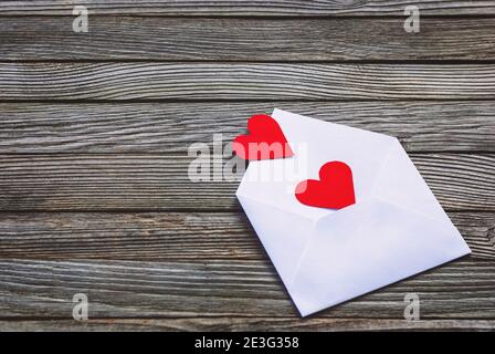 Coeurs en papier rouge dans une enveloppe sur fond en bois Banque D'Images