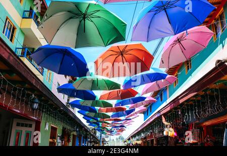 Rue avec des décorations de parapluie colorées à Pueblo Guatape, Colombie Banque D'Images