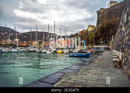 Vue unique sur un village italien sur la mer Méditerranée avec port touristique et maisons colorées pendant une journée d'hiver nuageux, Lerici, la Spezia Banque D'Images