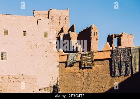 Tapis traditionnel arabe exposé sur les maisons berbères dans la kasbah d'Ouarzazate, au Maroc Banque D'Images