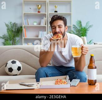 Le man eating pizza à emporter à la maison avoir un repos relaxant Banque D'Images