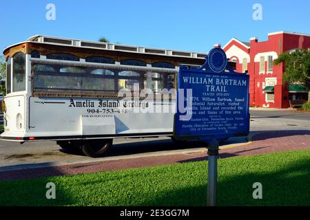 Un bus de visite d'époque de l'île Amelia trolleys, dans le quartier historique de Fernandina Beach, avec le signe historique pour le naturaliste, William Bartram, FL Banque D'Images