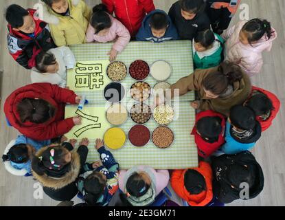 Xuzhou, Chine. 18 janvier 2021. Pour faire avancer la culture traditionnelle, un professeur enseigne aux jeunes enfants les connaissances sur les grains au festival de Laba dans la maternelle à Xuzhou, Jiangsu, en Chine, le 18 janvier 2021.(photo de TPG/cnschotos) crédit: TopPhoto/Alay Live News Banque D'Images