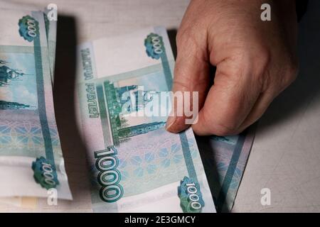 Une femme âgée compte mille roubles de factures. Mains et argent de la vieille femme. Vieillesse, épargne-retraite et concept d'investissement. Banque D'Images