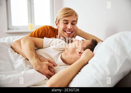 Un couple gay heureux allongé au lit le matin Banque D'Images