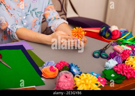 Femme modélisant la fleur artificielle de l'argile Banque D'Images