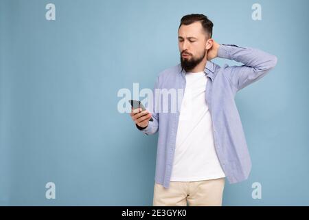 Photo d'un beau positif attentionné et beau jeune homme porter un ensemble décontracté et stylé poising isolé sur fond avec vide espace Banque D'Images