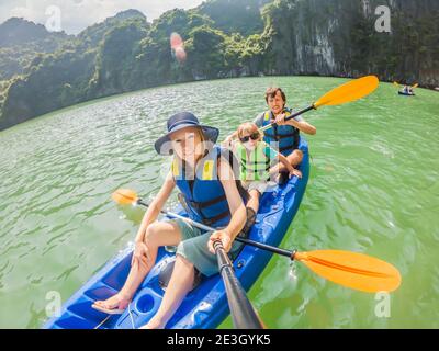 Maman, papa et fils qui raviront sur un kayak à Halong Bay. Vietnam. Voyage en Asie, bonheur émotion, concept de vacances d'été. Voyager avec Banque D'Images