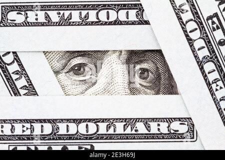Gros plan des yeux de Benjamin Franklin entre des billets de cent dollars. Banque D'Images