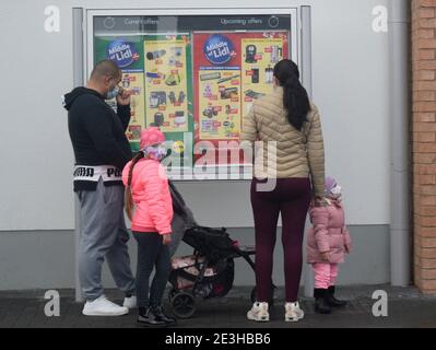 Une famille s'alignant à l'extérieur d'un magasin pendant le second maintien en Angleterre. Banque D'Images