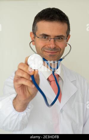 Portrait d'un médecin souriant avec stéthoscope à la main regardant l'appareil photo. Banque D'Images