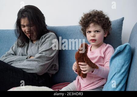 Interaction de deux sœurs sur un canapé dans le salon Banque D'Images