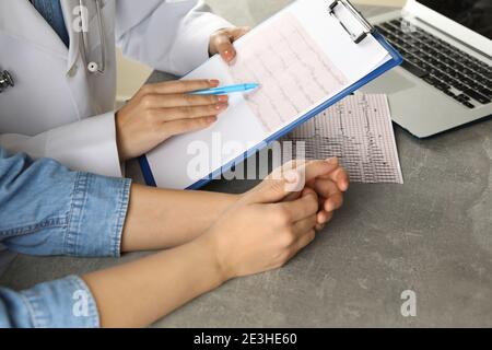Femme médecin vérifiant les résultats de l'électrocardiogramme avec le patient Banque D'Images
