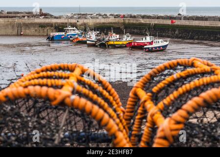 Vue sur les bateaux du port de Staithes, dans le North Yorkshire, au Royaume-Uni, avec des pots de homard au premier plan Banque D'Images