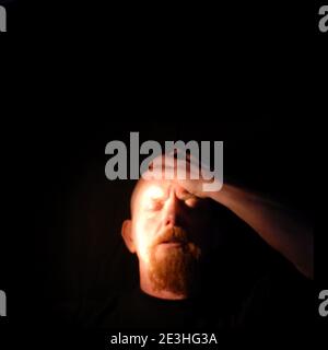 portrait de la tête de l'homme éclairé par un torchlight sur fond noir Banque D'Images
