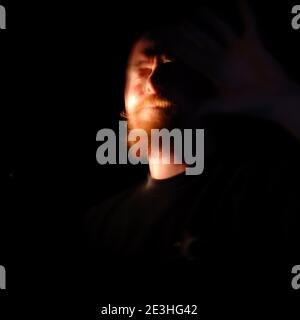 portrait de la tête de l'homme éclairé par un torchlight sur fond noir Banque D'Images