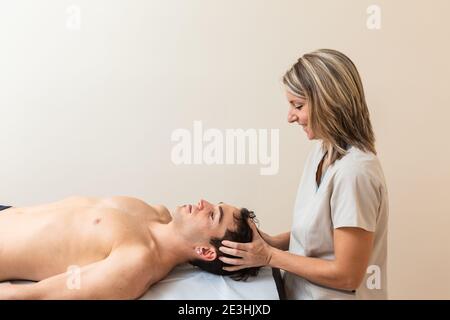 physiothérapeute ne session à l'homme. manipulation cervicale, trapezium stretch Banque D'Images