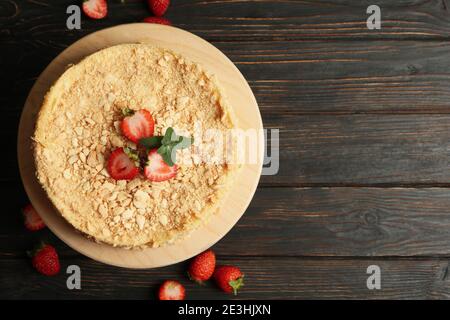 Planche avec gâteau Napoléon avec fraise sur fond de bois Banque D'Images