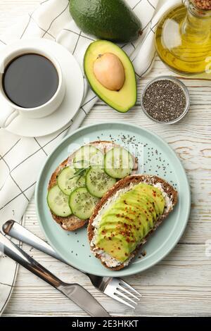 Concept de petit déjeuner avec toasts avec avocat et concombre table en bois Banque D'Images