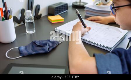 Adolescent faisant ses devoirs dans sa chambre Banque D'Images