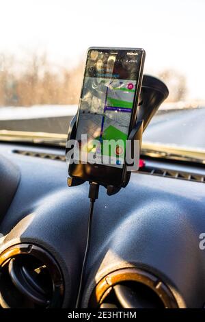 Utilisation de l'application waze Maps sur le smartphone dans le tableau de bord de la voiture. Chauffeur utilisant l'application cartes pour afficher le bon itinéraire à travers le trafic à Bucarest, Romani Banque D'Images