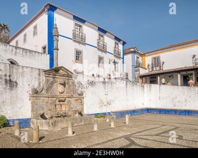 11 mars 2020: Obidos, Portugal - la place principale de la ville fortifiée d'Obidos, avec le Pelourinho ou Pillory à gauche. Banque D'Images