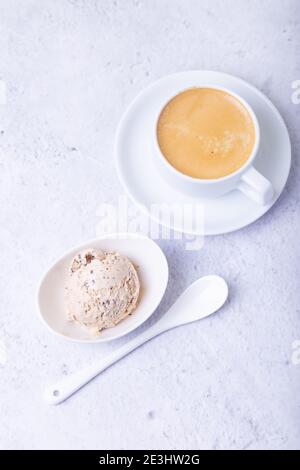 Glace maison avec chips de chocolat dans un bol. Une boule de glace et une tasse de café. Gros plan. Banque D'Images