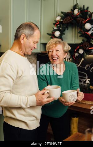 Photo d'un couple âgé des années 60 qui profite de la vie dans la cuisine avec des tasses de café. st Valentin jour des vieux couples amoureux. Cesser la discrimination de l'âgisme Banque D'Images