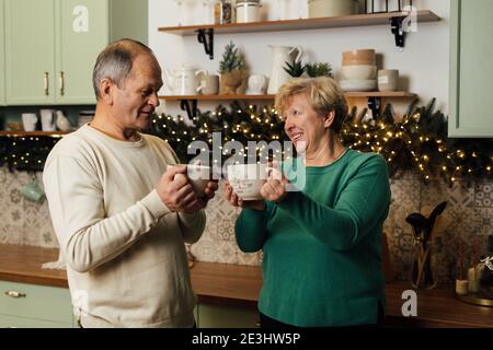 Photo d'un couple âgé des années 60 qui profite de la vie dans la cuisine avec des tasses de café. st Valentin jour des vieux couples amoureux. Cesser la discrimination de l'âgisme Banque D'Images