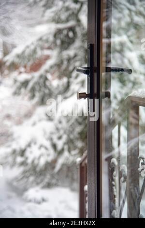 Vue sur la cour enneigée par la porte vitrée du cottage. Banque D'Images