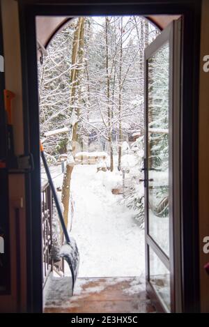 Vue sur la cour enneigée par la porte vitrée du cottage. Banque D'Images