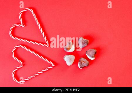 Fond rouge festif. Cœurs et bonbons sucrés. Saint Valentin. 14 février. Idées de cadeaux. Flat lay, vue de dessus. Banque D'Images