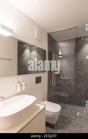 Intérieur moderne avec murs blancs et parquet. Salle de bains moderne en pierre, minimaliste. Personne à l'intérieur Banque D'Images