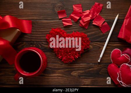 Saint-Valentin, fabrication de cadeaux, bricolage. Peper et coeurs feutres, tasse à thé et boîte cadeau sur fond de bois. Concept de Saint-Valentin, fête des mères et anniversaire Banque D'Images