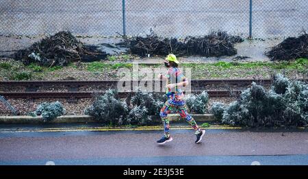 Brighton Royaume-Uni 19 janvier 2021 - UN coureur habillé de couleurs brave les conditions sur le front de mer de Brighton alors que Storm Christoph arrive en Grande-Bretagne avec de forts vents de pluie et de neige au cours des prochains jours avec des avertissements météorologiques ambres déjà donnés pour certaines parties avec des inondations attendues : Credit Simon Dack / Alamy Live News Banque D'Images