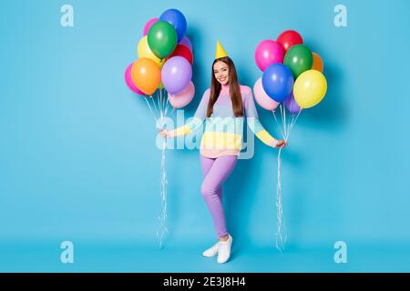 Vue sur toute la longueur de la taille du corps de jolie fille gaie tenue dans les mains pelotes hélium célébration isolé bleu vif fond de couleur Banque D'Images