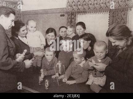 Travailleurs de l'usine de Krasny Bogatyr avec des enfants adoptés dont les parents sont morts pendant la guerre en 1942. Banque D'Images