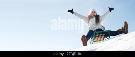 En hiver, la femme s'assoit et se couche de neige sur fond de neige et de ciel. Bannière pour station de ski. Banque D'Images