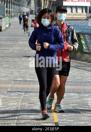 Hong Kong, Chine. 19 janvier 2021. Les joggeurs portant un masque facial courent le long de la Promenade à Hong Kong, dans le sud de la Chine, le 19 janvier 2021. Le gouvernement de la région administrative spéciale de Hong Kong (HKSAR) a annoncé mardi l'extension des mesures de distanciation sociale pour une autre semaine jusqu'au 27 janvier, 56 autres cas confirmés de COVID-19 ayant été signalés. Crédit : Lo Ping Fai/Xinhua/Alamy Live News Banque D'Images