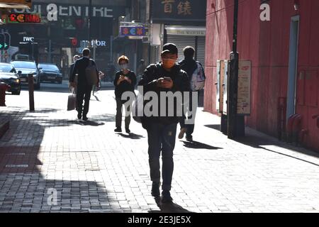 Hong Kong, Chine. 19 janvier 2021. Des piétons portant des masques de visage marchent le long d'une rue à Hong Kong, dans le sud de la Chine, le 19 janvier 2021. Le gouvernement de la région administrative spéciale de Hong Kong (HKSAR) a annoncé mardi l'extension des mesures de distanciation sociale pour une autre semaine jusqu'au 27 janvier, 56 autres cas confirmés de COVID-19 ayant été signalés. Crédit : Lo Ping Fai/Xinhua/Alamy Live News Banque D'Images