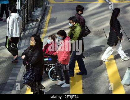 Hong Kong, Chine. 19 janvier 2021. Des piétons portant un masque facial traversent une rue à Hong Kong, dans le sud de la Chine, le 19 janvier 2021. Le gouvernement de la région administrative spéciale de Hong Kong (HKSAR) a annoncé mardi l'extension des mesures de distanciation sociale pour une autre semaine jusqu'au 27 janvier, 56 autres cas confirmés de COVID-19 ayant été signalés. Crédit : Lo Ping Fai/Xinhua/Alamy Live News Banque D'Images