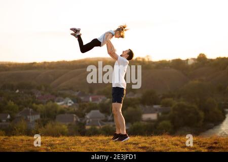 Famille active. Père et fille s'amusent ensemble. Papa jette sa fille dans le ciel Banque D'Images