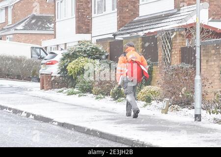 Kidderminster, Royaume-Uni. 2 janvier 2021. Météo au Royaume-Uni: Les travailleurs postaux du Royal Mail sont des travailleurs essentiels dans nos temps de confinement. Quelles que soient les conditions météorologiques, ils brave les éléments pour s'assurer que notre poste est livré. Ce postier est vu, de l'arrière, sur ses tours face aux conditions hivernales comme la neige tombe. Banque D'Images