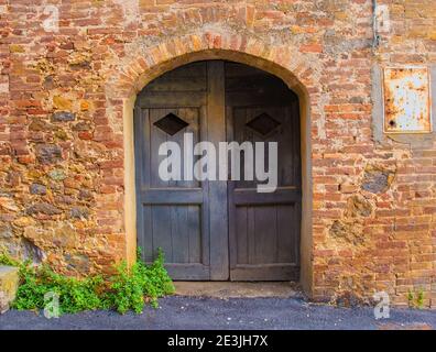 Une ancienne porte en bois dans un bâtiment résidentiel désutilisé dans le centre historique de la ville médiévale de Monticiano dans la province de Sienne, Toscane, Italie Banque D'Images