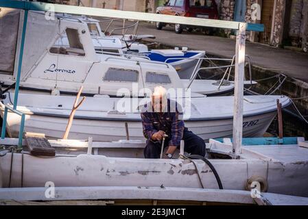 Homme âgé qui fixe son bateau, Port au Mali Iz, île d'Iz, archipel de Zadar, Dalmatie, Croatie Banque D'Images