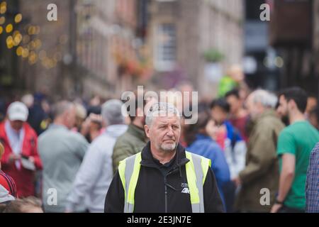 Édimbourg, Écosse - 6 2017 août : un responsable de la sécurité du château d'Édimbourg qui garde un œil sur les foules animées du festival Edinburgh Fringe, le long du Roy Banque D'Images